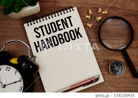 Student Handbook text written on notepad with alarm clock, compass and magnifying glass flat lay on wooden background Student Handbook text written on notepad with alarm clock, compass and magnifying glass flat lay on wooden background 138238435