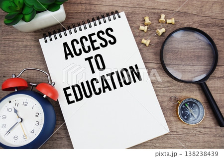 Access To Education text written on notepad with alarm clock, compass and magnifying glass flat lay on wooden background 138238439