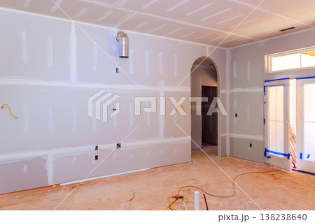 Work underway in new home with drywall being installed, electrical wiring set up in room before completion. 138238640