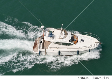 White motor yacht cruising on green sea water White motor yacht cruising on green sea water 138239149