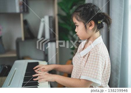 Young Girl Playing Piano in Cozy Home Environment, Focusing on Music Skills and Creative Expression, Interior Design Elements in Background 138239946