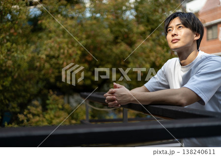 屋外で考え事をしている一人の若い男性 138240611