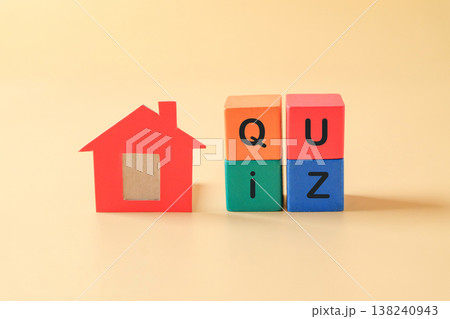 Small red dollhouse with QUIZ text on wood cube. Small red dollhouse with QUIZ text on wood cube. 138240943