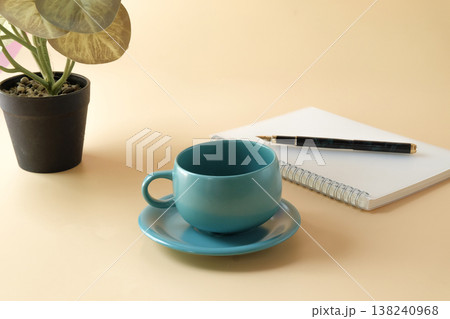 A cup of coffee with notepads and pen on desk. 138240968