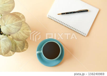A cup of coffee with notepads and pen on desk. 138240969