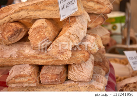 Rustic loaves of bread with a golden crust displayed on a local market table in Aix-en-Provence, a French gastronomic atmosphere Rustic loaves of bread with a golden crust displayed on a local market table in Aix-en-Provence, a French gastronomic atmosphere 138241956