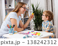 Woman and boy engaging in educational activity at table with colorful learning materials 138242312