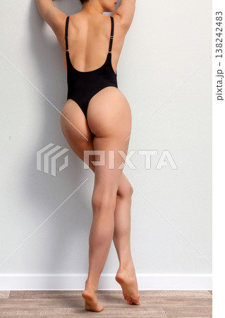 Young adult woman in black lingerie standing by the grey wall Young adult woman in black lingerie standing by the grey wall 138242483