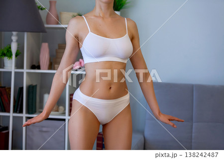 young adult woman in white bikini at home young adult woman in white bikini at home 138242487