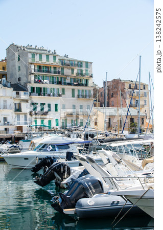 明るい日差しの下の遮光扉の付いたパステルカラーの建物　地中海に浮かぶフランス領のコルシカ島にて 138242575