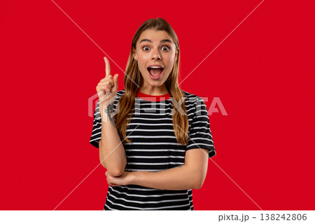 Happy woman having idea eureka moment, pointing finger up on red background. Clever lady showing answer gesture or remembered what she forgot, memory concept. Happy woman having idea eureka moment, pointing finger up on red background. Clever lady showing answer gesture or remembered what she forgot, memory concept. 138242806
