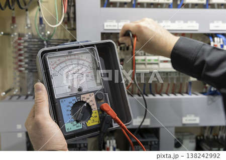 制御盤の保守点検を行う電気工事士 アナログテスターを用いた電圧測定と設備管理のイメージ 制御盤の保守点検を行う電気工事士 アナログテスターを用いた電圧測定と設備管理のイメージ 138242992