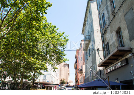 明るい日差しの下の遮光扉の付いたパステルカラーの建物　地中海に浮かぶフランス領のコルシカ島にて 138243021