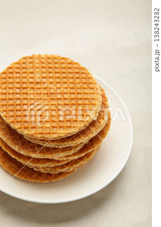 Stack of Dutch stroopwafel cookies or caramel waffles on plate on light background. Vertical photo Stack of Dutch stroopwafel cookies or caramel waffles on plate on light background. Vertical photo 138243282