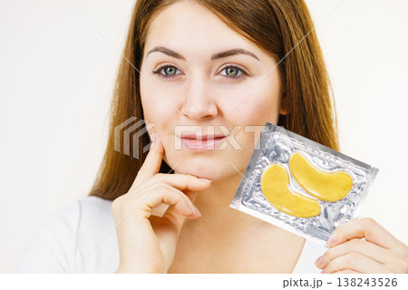 Woman ready to apply gold eye patches Woman ready to apply gold eye patches 138243526