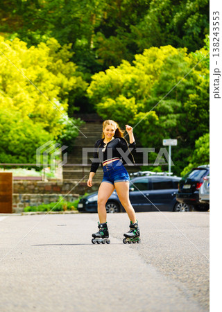 Young woman riding roller skates 138243553