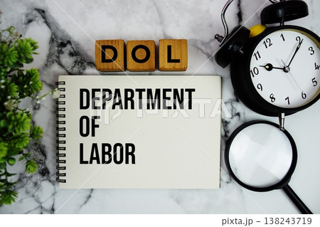 DOL Department of Labor text with alarm clock and magnifying glass on marble background DOL Department of Labor text with alarm clock and magnifying glass on marble background 138243719