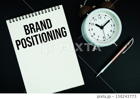 Brand Positioning text written on notepad with pen and alarm clock 138243773