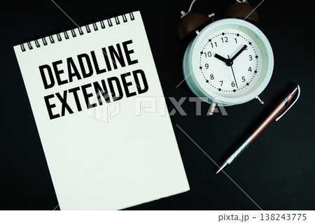 Deadline Extended text written on notepad with pen and alarm clock 138243775