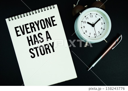 Everyone Has A Story text written on notepad with pen and alarm clock 138243776
