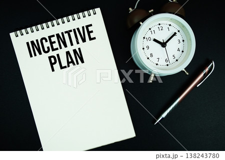 Incentive Plan text written on notepad with pen and alarm clock 138243780