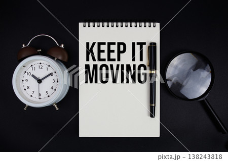 Keep It Moving text written on notepad with alarm clock top view on black background Keep It Moving text written on notepad with alarm clock top view on black background 138243818