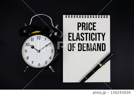 Price Elasticity of Demand (PED) text written on notepad with alarm clock top view on black background 138243830