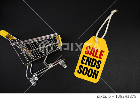 Mini Trolley Shopping Cart and price tag with message "Sale Ends Soon" on black background 138243879