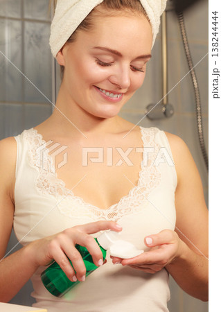Woman with cotton swab cleaning her skin. 138244444