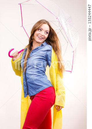 Woman wearing waterproof coat under umbrella 138244447