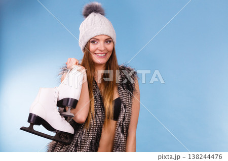 Woman holding ice skates, winter sport Woman holding ice skates, winter sport 138244476