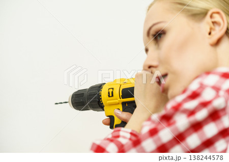 Woman drilling in wall Woman drilling in wall 138244578