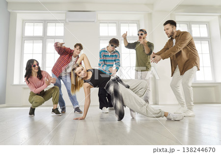 Happy woman on a sport training with young people dancers showing dance movements. Happy woman on a sport training with young people dancers showing dance movements. 138244670