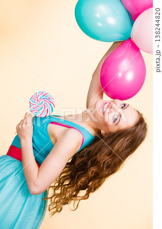 Woman with colorful balloons and lollipop 138244820