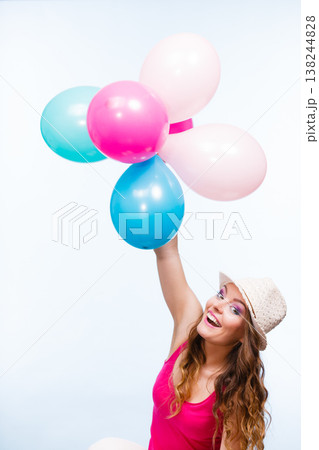 Woman playing with many colorful balloons 138244828