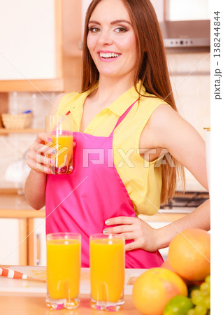Woman in kitchen drinking fresh orange juice Woman in kitchen drinking fresh orange juice 138244844