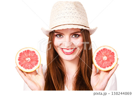 Woman holds two halfs of grapefruit citrus fruit in hands 138244869
