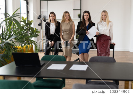 Group of four diverse businesswomen posing together in a bright, contemporary office, symbolizing collaboration, success, leadership, and professional women in the workplace as an accomplished team Group of four diverse businesswomen posing together in a bright, contemporary office, symbolizing collaboration, success, leadership, and professional women in the workplace as an accomplished team 138244902