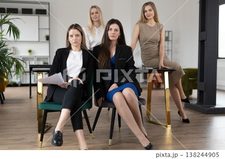 Professional businesswomen team collaborating and discussing work, showing unity, leadership, and empowerment while posing in a contemporary office setting Professional businesswomen team collaborating and discussing work, showing unity, leadership, and empowerment while posing in a contemporary office setting 138244905