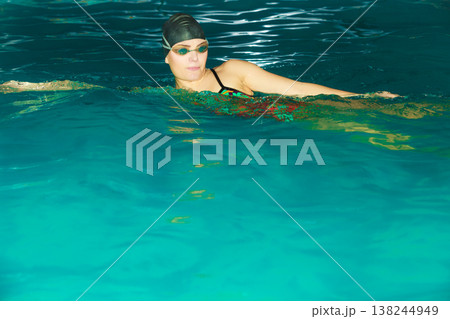 Woman athlete swimming crawl stroke in pool. Woman athlete swimming crawl stroke in pool. 138244949