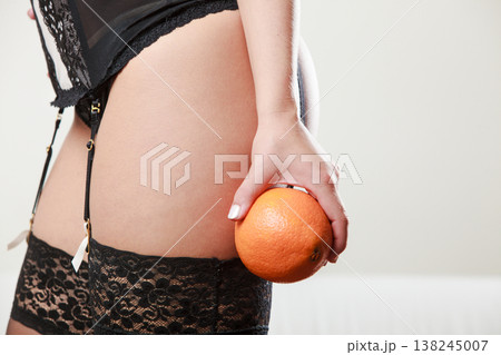 Girl holding orange next to bottom 138245007