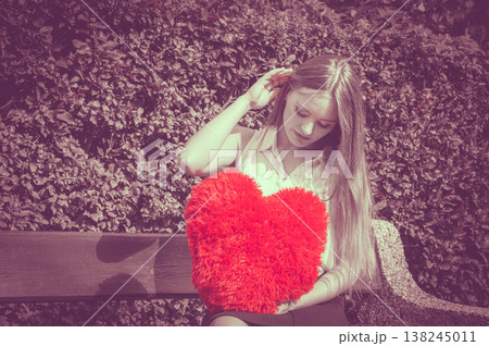 Disappointed woman with big red heart 138245011