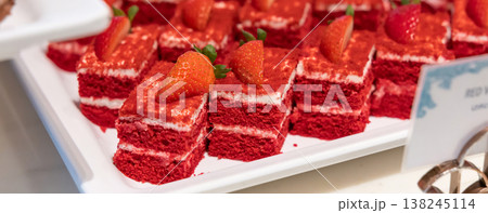 Many pieces of white cake and decorate by pink chocolate heart shape in buffet line. Many pieces of white cake and decorate by pink chocolate heart shape in buffet line. 138245114