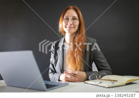 Professional woman working at desk smiling at camera Professional woman working at desk smiling at camera 138245287