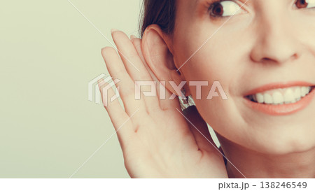 Gossip girl eavesdropping with hand to ear. 138246549