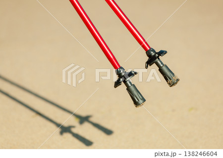Nordic walking. Red sticks on the sandy beach 138246604