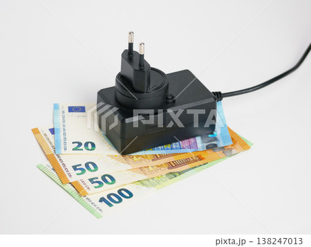 Power adapter with euro banknotes showing rising energy cost Power adapter with euro banknotes showing rising energy cost 138247013