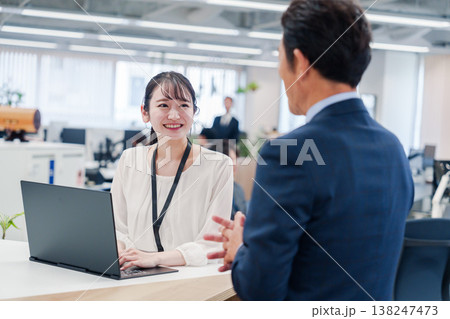 役所の窓口で高齢者に対応する女性スタッフ 役所の窓口で高齢者に対応する女性スタッフ 138247473
