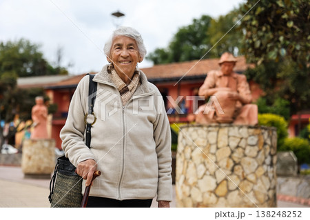 Happy senior lifestyle concept. Senior woman at the central square of the beautiful small town of Raquira. The city of pots in Colombia. Happy senior lifestyle concept. Senior woman at the central square of the beautiful small town of Raquira. The city of pots in Colombia. 138248252