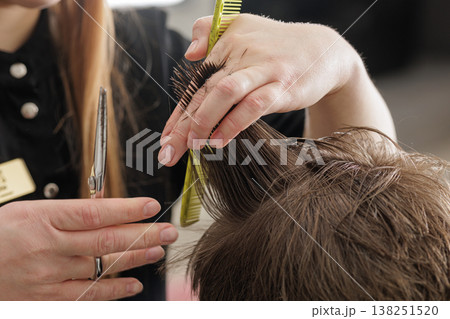 Hairdresser trims wet hair using scissors and comb during a haircut. Close-up of hands and hair sectioning in salon, grooming service, hygiene, and care concept. Hairdresser trims wet hair using scissors and comb during a haircut. Close-up of hands and hair sectioning in salon, grooming service, hygiene, and care concept. 138251520